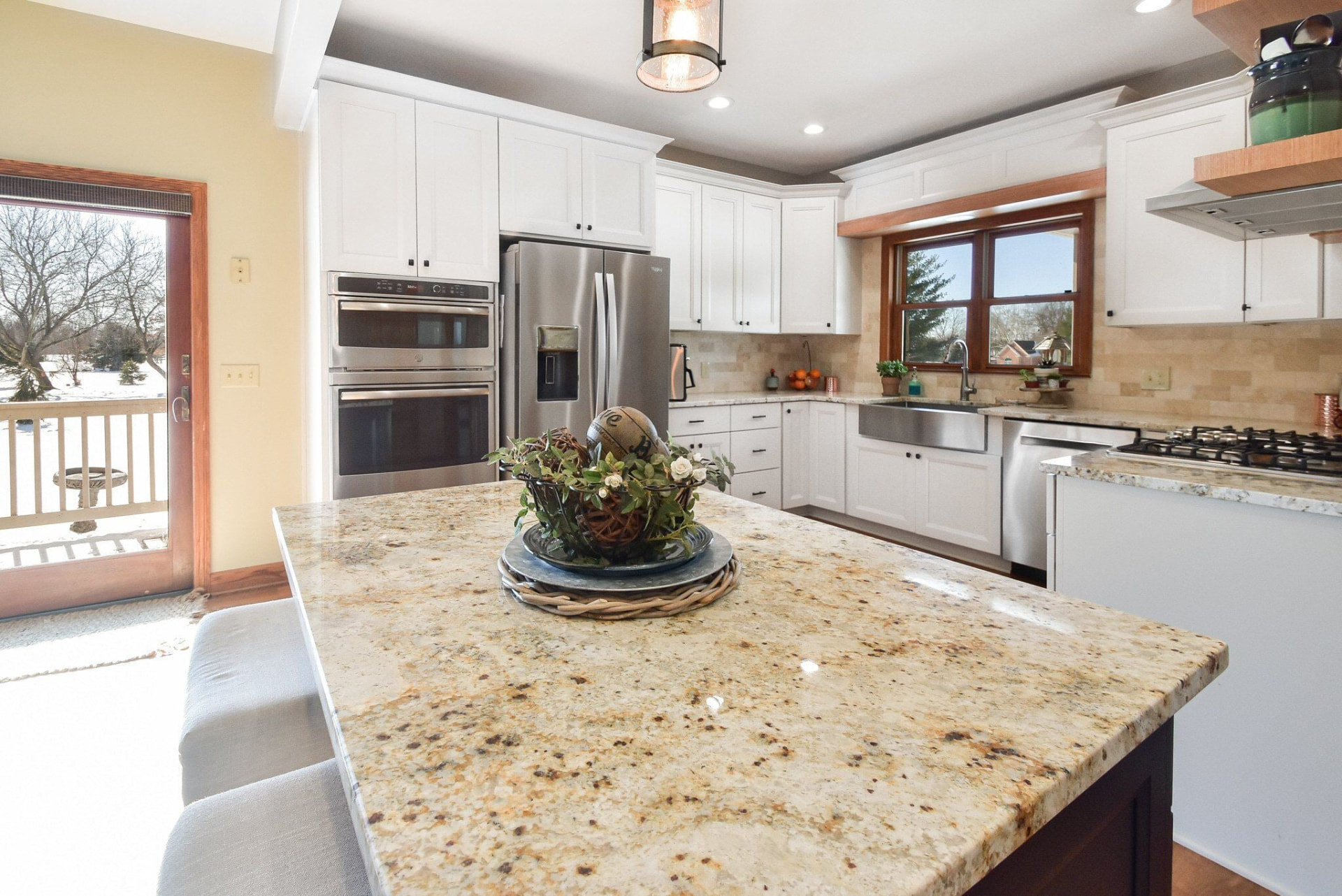 Granite island countertop in a bright white Sunny Isles, Florida kitchen