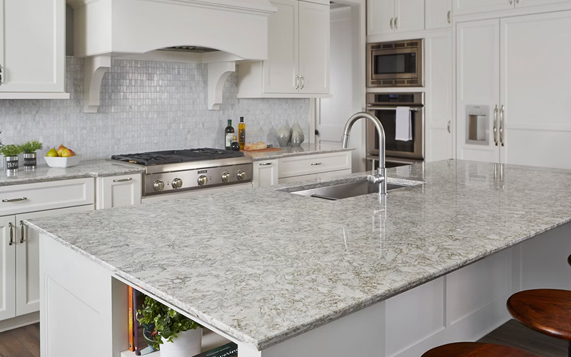 Speckled granite kitchen countertop installed with white cabinetry