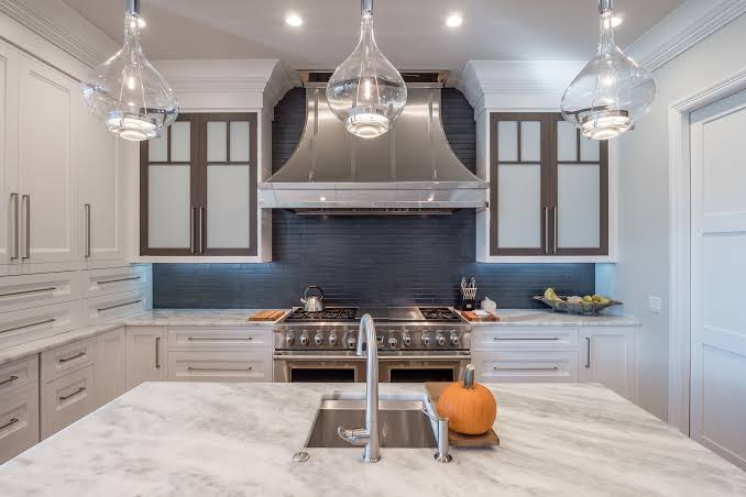 Custom kitchen with navy tile backsplash and marble island