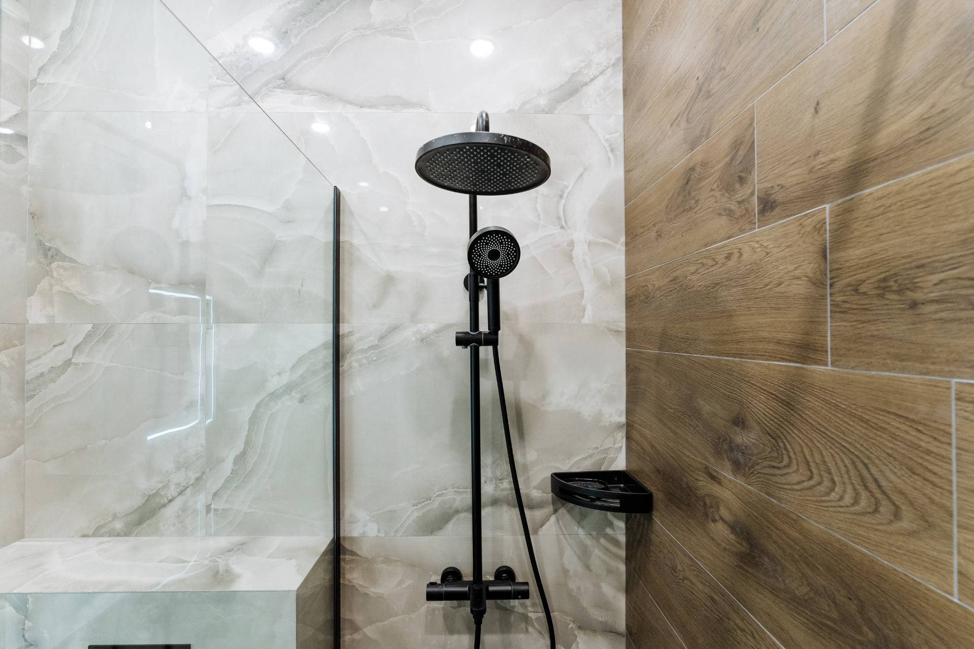 Marble-tiled walk-in shower with matte black fixtures in Bal Harbour, FL