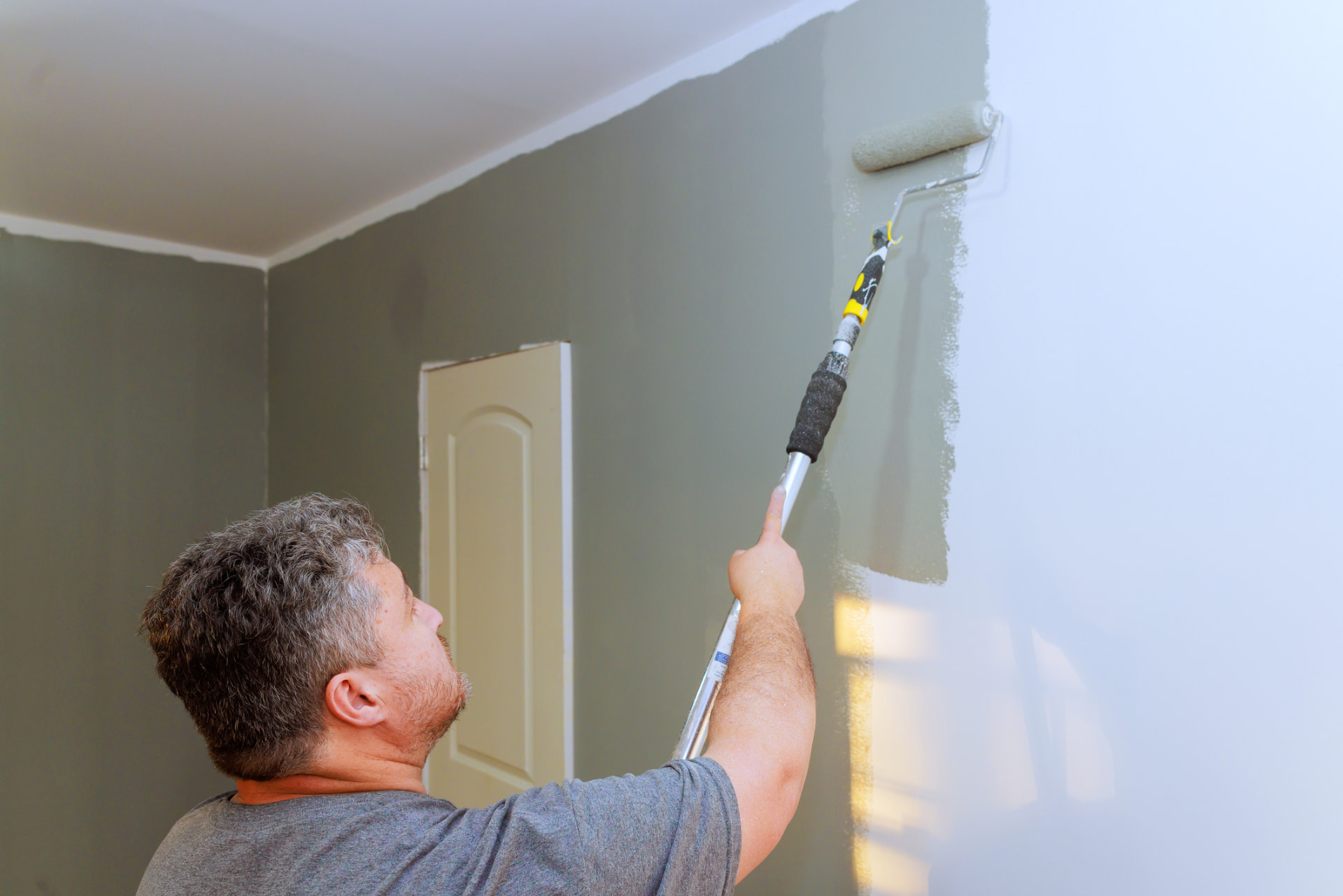 Painter rolling fresh interior wall paint in Golden Beach, FL