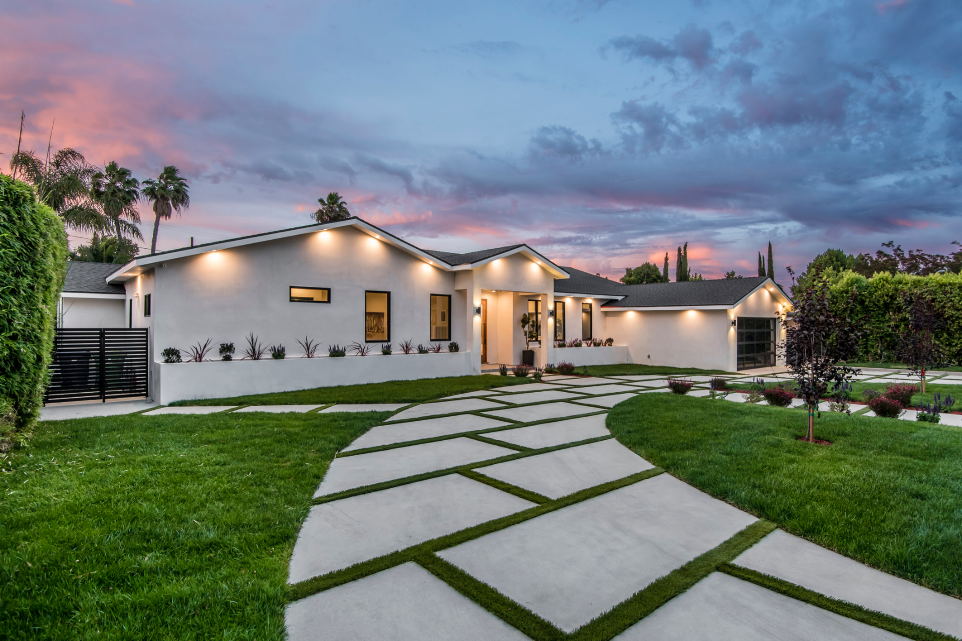 Modern white stucco home exterior remodel at dusk in Jupiter, FL